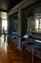 Elegant interior with chic bar area, featuring modern stools, glass accents, and rich wooden flooring, exuding luxury and sophistication.