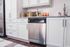 Sleek modern kitchen featuring white cabinets, stainless steel dishwasher, and granite countertops with stylish beverage setup.