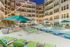 Luxurious apartment complex with a stunning outdoor pool, cozy loungers, and vibrant umbrellas, perfect for relaxation and leisure.