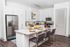 Modern kitchen with granite countertops, stainless steel appliances, and stylish bar seating, perfect for entertaining guests.