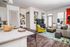 Bright and modern living area with a stylish open kitchen, chic dining bar, and vibrant decor. Features a cozy living space with green accents and artistic wall art.