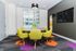 Modern meeting room with vibrant yellow chairs around a round table, large window views, and a sleek wall-mounted TV.