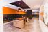 Modern apartment mailroom with sleek black mailboxes, vibrant orange accents, and stylish pendant lighting.