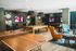 Vibrant entertainment lounge featuring a stylish ping-pong table, cozy seating, and modern decor with mounted TVs.