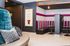 Chic apartment lounge with cozy striped seating, stylish decor, and ambient lighting.