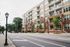 Modern urban apartment complex with large balconies, lush greenery, and stylish brick facade, ideal for city living.