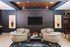 Chic modern lounge with stylish neutral chairs, vibrant artwork, and a sophisticated patterned accent wall.
