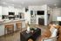 Modern apartment interior with open-concept kitchen featuring a sleek countertop and cozy living area with stylish decor.