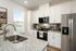 Modern kitchen with sleek white cabinets, granite countertops, and stainless steel appliances, offering a bright and inviting cooking space.