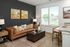 Modern living room with a stylish leather sofa, elegant coffee table, and large windows for natural light.