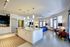 Chic open-concept apartment interior with spacious kitchen island, contemporary lighting, and cozy living area.