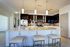 Modern kitchen with sleek countertops, stainless steel appliances, and elegant pendant lighting.
