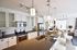 Modern open-concept kitchen and living area with sleek countertops, stainless steel appliances, and elegant lighting features.
