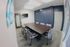 Modern conference room with sleek design, featuring a large table, comfortable seating, and vibrant wall art.