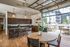 Chic apartment interior with a modern kitchen, elegant lighting, and a bright open layout leading to a stylish patio area.