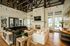 Elegant apartment lounge area featuring plush sofas, a modern fireplace, high ceilings with stylish lighting, and large windows offering natural light.