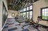 Modern, bright fitness center with state-of-the-art treadmills, rowing machines, and exercise bikes, featuring large windows and stylish industrial design.