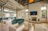 Chic and modern living room with plush blue sofa, elegant fireplace, and natural light from large windows, perfect for cozy gatherings.
