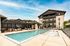 Luxurious apartment complex featuring a sparkling outdoor pool, elegant poolside seating, and stylish modern architecture.