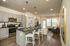 Modern open-concept kitchen and living area with sleek stainless steel appliances, elegant pendant lighting, and cozy seating, offering a warm and inviting atmosphere.