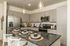Contemporary kitchen with elegant granite countertops, modern stainless steel appliances, and sleek pendant lighting over a central island with stylish place settings.
