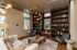 Inviting living space with elegant built-in shelves, cozy armchairs, and abundant natural light, creating a stylish reading nook.