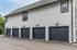 Charming multi-car garage with sleek modern doors and stylish outdoor lighting, perfect for secure parking.