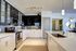 Sleek modern kitchen with glossy cabinets, stainless steel appliances, and a spacious island, perfect for entertaining and culinary creativity.