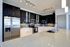 Modern kitchen with sleek black and white cabinetry, stainless steel appliances, and elegant track lighting. Spacious island with integrated sink and polished countertops for a stylish culinary space.