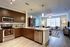 Inviting open-concept kitchen and living room with modern appliances, stylish wooden cabinetry, and abundant natural light.