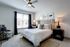 Elegant bedroom with a plush bed, stylish accent chair, and modern decor creating a cozy retreat.
