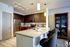 Modern kitchen boasting sleek stainless steel appliances, elegant dark wood cabinets, and a stylish breakfast bar with cozy seating.