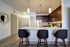 Modern kitchen with a sleek island, bar stools, stainless steel appliances, and warm wood cabinetry, perfect for entertaining.