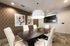 Elegant conference room with modern decor, featuring a sleek dark wood table, white leather chairs, stylish pendant light, and artistic wall designs.