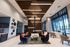 Elegant lobby area with modern seating, artistic wood ceiling, and vibrant decor.