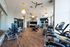 Modern fitness center featuring state-of-the-art gym equipment, vibrant yellow pendant lights, and sleek wood flooring, perfect for an energetic workout experience.