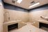 Modern apartment utility room with sleek tiled surfaces and efficient lighting, showcasing a spacious and clean design.