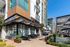 Vibrant outdoor dining area at a contemporary apartment complex, showcasing stylish architecture and greenery for an upscale urban living experience.