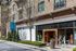 Charming urban storefront at Avalon with stylish architecture and welcoming entrance, surrounded by lush greenery.