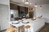 Modern kitchen with sleek wood cabinetry, stainless steel appliances, and spacious island with seating for two.