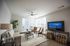 Bright and inviting living room with plush seating, sleek furniture, and large windows letting in natural light.