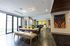 Contemporary open dining and living area with stylish decor, vibrant artwork, and abundant natural light from large glass doors.
