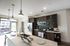 Modern kitchen with sleek stainless steel appliances, elegant pendant lighting, and a spacious island featuring a built-in sink and seating area.