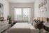 Elegant bedroom with stylish decor, large window, and plush bedding for a cozy ambiance.