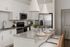 Elegant modern kitchen with sleek granite countertops, stainless steel appliances, and chic pendant lighting.