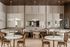 Elegant dining area featuring modern round tables, stylish wooden chairs, and cozy booth seating with chic pendant lighting and decorative mirrors.