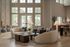 Spacious, light-filled living room with modern decor, plush seating, and elegant floor-to-ceiling windows offering a stunning view of palm trees.