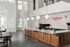 Modern coffee shop interior with sleek design, spiral staircase, and warm wooden elements under soft globe lighting.