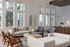 Elegant living room with high ceilings, large picture windows, and stylish modern furniture, creating a bright and inviting space.