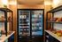 Inviting snack bar featuring a well-stocked refrigerator with assorted beverages and a variety of snacks displayed on sleek shelving.